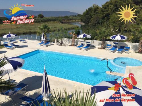 弗切瓦拉诺Summer Holidays Residence的度假村的游泳池,配有椅子和遮阳伞