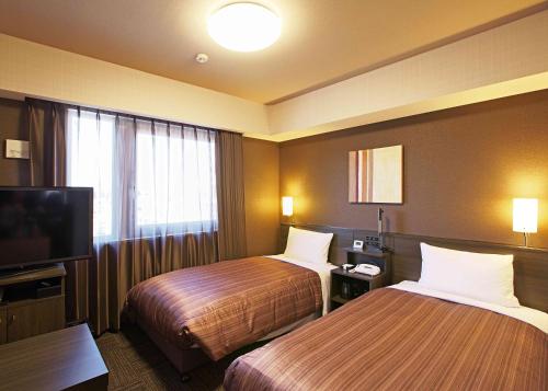 SabaeHotel Route-Inn Sabae -Kokudou 8 Gou-的酒店客房设有两张床和一台平面电视。