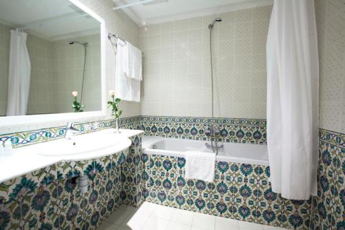 马赫迪耶埃尔莫拉蒂卡普玛哈蒂亚酒店的带浴缸、水槽和镜子的浴室