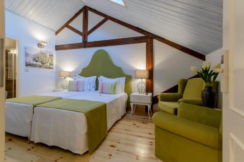 波尔蒂芒Villa Rio Guest House Suites的一间卧室配有一张大床和一张绿色沙发