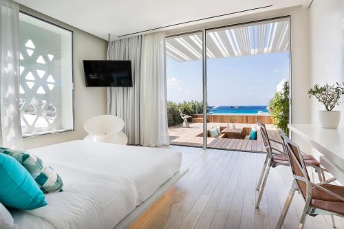 普拉迪斯亚罗斯Mykonos Dove Beachfront Hotel的一间卧室配有一张床,享有海景