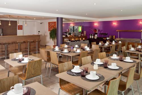 梅斯雷斯迪家梅兹洛莱娜的餐厅设有桌椅和紫色墙壁