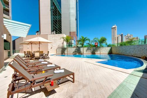戈亚尼亚K酒店 的一座带椅子的庭院和一座位于大楼内的游泳池