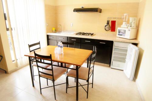 萨卡特卡斯Hotel y Suites El Refugio de Don Carlos的厨房配有木桌和一些椅子