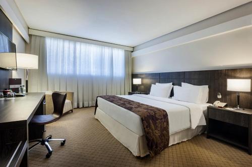 戈亚尼亚K酒店 的酒店客房设有一张大床和一张书桌。