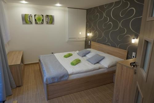 Ratíškovice斯特畔卡公寓的一间卧室配有一张带两个绿色枕头的床