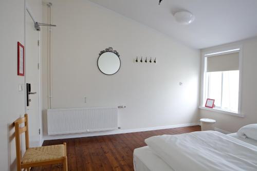 阿克雷里阿库雷里背包客旅馆的白色的卧室设有一张床和墙上的镜子