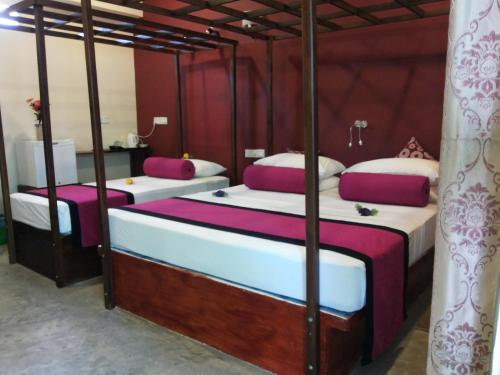 米瑞莎斯拉小屋酒店的紫白色客房的两张床
