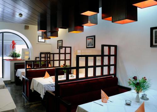 特罗吉尔莫妮卡酒店的餐厅设有2张桌子和椅子以及灯光