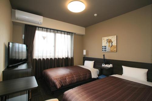 名取市仙台国际机场名取岩沼路线酒店的酒店客房设有两张床和一台平面电视。