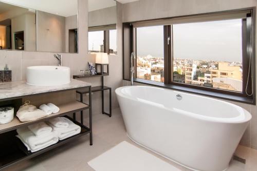 鹿港镇鹿港永乐酒店的带浴缸、水槽和窗户的浴室