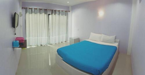 柴老海滩南赛阁楼度假村的一间卧室设有蓝色的床和窗户。