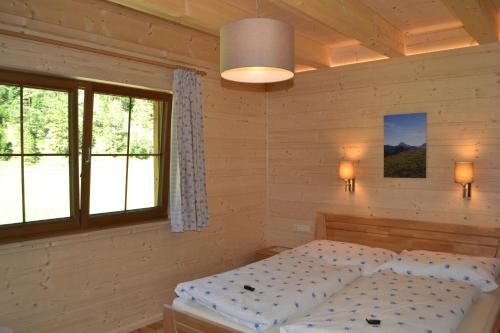 阿亨基希Ferienwohnung Hinterwinkl的一间卧室设有一张床和两个窗户。