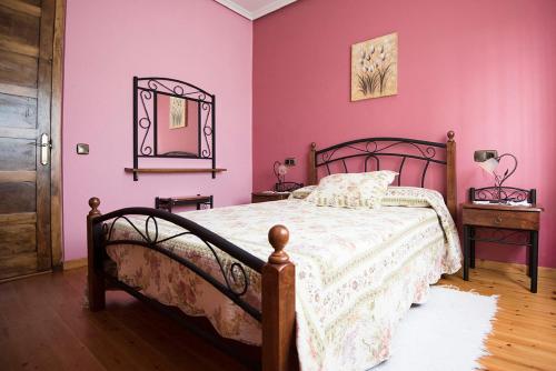 卢安科Maria la Carbayeda的一间卧室配有一张粉红色的墙壁和镜子