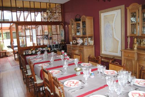 博尔赫隆赫特兰德霍夫住宿加早餐旅馆的用餐室配有带盘子和玻璃杯的桌子