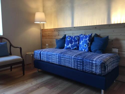 维琴察Agriturismo Corte Bertesina的一间卧室配有一张带蓝色枕头的床和一把椅子