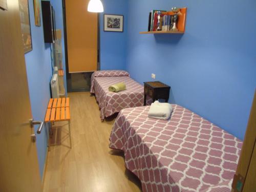 阿尔卡尼斯Apartamentos Mequedo的蓝色墙壁客房的两张床