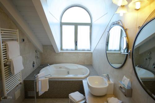 都灵贝斯特韦斯特水晶宫酒店的带浴缸、水槽和镜子的浴室
