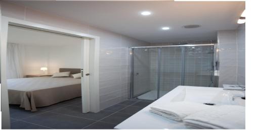 坎布里尔斯Apartamentos Ocea的一间卧室配有一张床、淋浴和浴缸