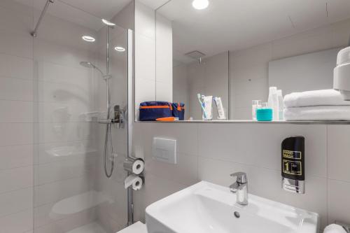 Rohrbrunn施佩萨特瑟维斯酒店的带淋浴和盥洗盆的白色浴室