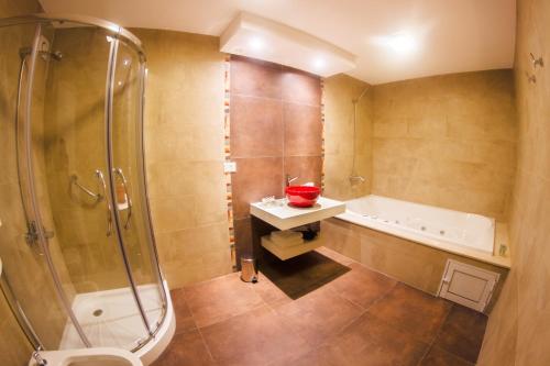 LeonesHotel Posada Maestosso的带浴缸、淋浴和盥洗盆的浴室