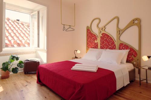 里斯本里斯本客房公寓的一间卧室配有一张带红色毯子的床和窗户。