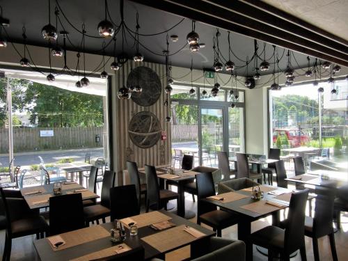 济夫努夫Armada Holiday House的餐厅设有木桌、椅子和窗户。