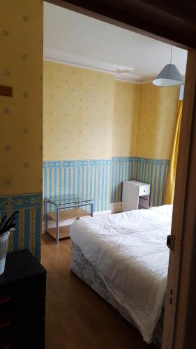 布莱克浦Wishing Well Guest House的卧室设有白色的床和黄色的墙壁
