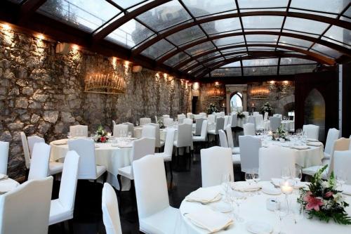戈特赫斯阿特亚加Hotel Castillo de Arteaga的用餐室配有白色的桌子和白色的椅子
