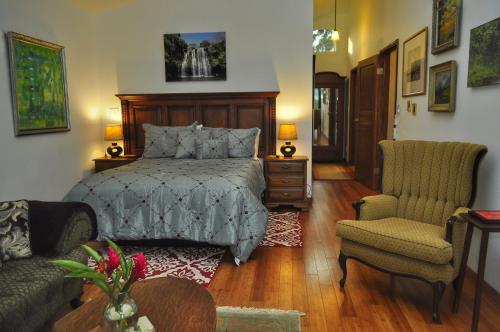 纽沃阿雷纳尔Casa Donna Rosa B&B的一间卧室配有一张床、一张沙发和一把椅子