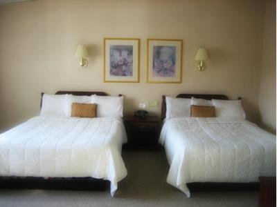 Hopewell Junction乔木岭酒店和会议中心的配有白色床单的酒店客房内的两张床