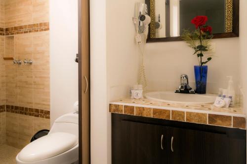 卡利Hotel Campestre Santa Monica Pance的一间带水槽的浴室和台面上的电话