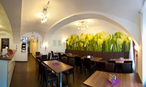 利帕河畔卡梅尼采伯格酒店的墙上有桌子和黄色郁金香的餐厅
