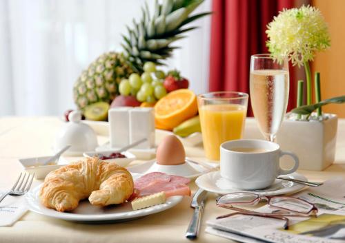 爱尔福特慕尼黑卡丽酒店的配有羊角面包和咖啡的早餐桌