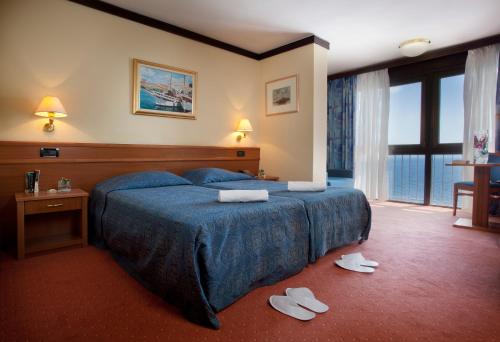 奥帕提亚Hotel Kristal - Liburnia的一间酒店客房,地板上配有一张床和拖鞋