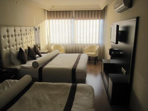 伊兹密尔爱丽丝1号酒店的酒店客房设有两张床和电视。