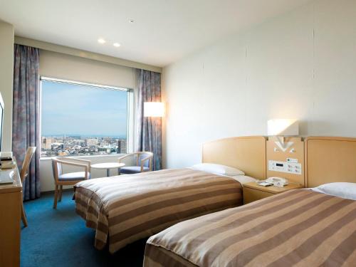 德岛德岛格兰维罗酒店的酒店客房设有两张床和大窗户。