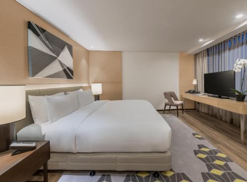 马尼拉Seda Vertis North的酒店客房设有一张大床和一台电视机。
