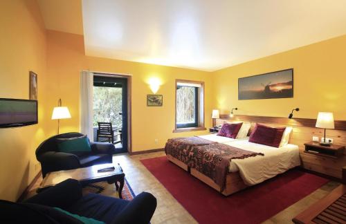 拉日什杜皮库Aldeia da Fonte Hotel的配有一张床和一把椅子的酒店客房
