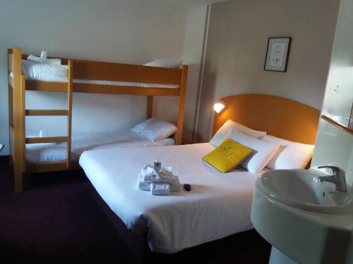 圣普列斯特Quick Palace Lyon Saint-Priest的酒店客房配有床、水槽和双层床。