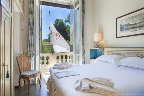 罗马阿尔德罗万迪城市套房酒店的一间卧室配有床,窗户外设有帆船