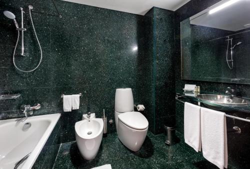 蓬塔德尔加达阿维尼达整洁酒店的浴室配有卫生间、浴缸和水槽。