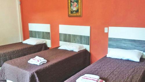 里奥格兰德Pousada Musleh的橙色墙壁客房的两张床