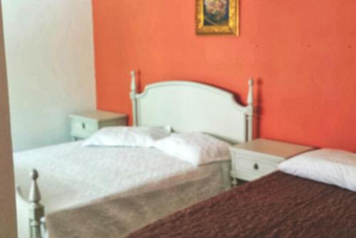 里奥格兰德Pousada Musleh的橙色墙壁客房的两张床