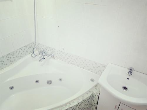 马盖特Dumela Margate Flat No 11的浴室设有白色浴缸和水槽。