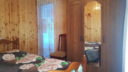 苏呼米Частный сектор的一间卧室配有一张床、镜子和椅子