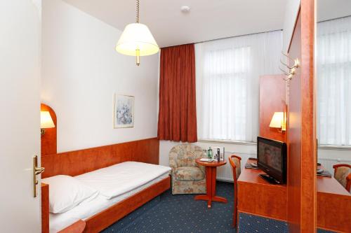 哥廷根汉诺威斯塔德特酒店的配有一张床和一把椅子的酒店客房