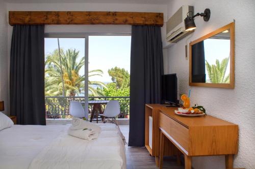 古厄庇道鲁斯Hotel Hellas的酒店客房配有一张床和一张带镜子的书桌