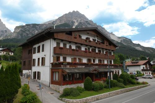 圣维托-迪卡多雷Hotel Albergo Dolomiti的山边街道上的建筑