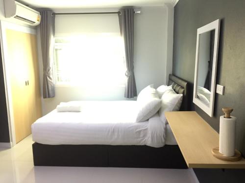 莱卡邦素万那普A普勒斯旅馆的卧室配有一张大白色床和窗户